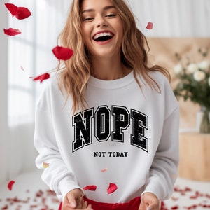 May include: White sweatshirt with black text that reads "NOPE NOT TODAY".