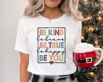 May include: White t-shirt with a colorful graphic that says "Be Kind, Be Brave, Be True, Be Happy, Be You".