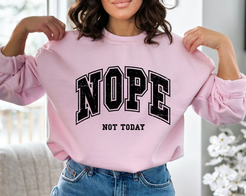 May include: Pink sweatshirt with black text that reads "NOPE NOT TODAY" in a vintage collegiate font.