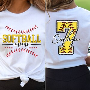 May include: White t-shirt with a softball design and the text "SOFTBALL mimi" on the front. The back of the shirt has a large yellow number 7 with a softball design and the name "Sophia" written in cursive.
