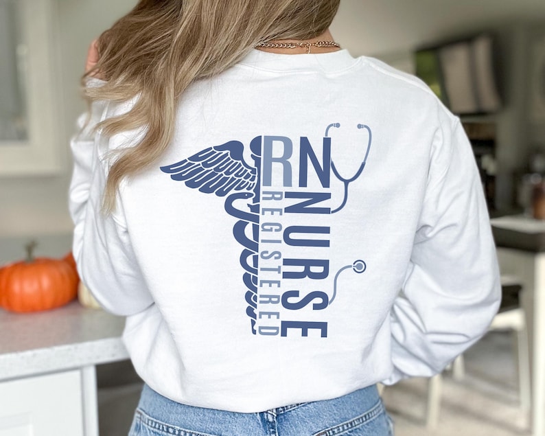 May include: White long-sleeve shirt with a blue graphic of a caduceus and the text "RN Registered Nurse".