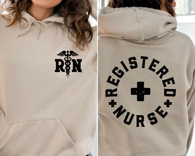 May include: A beige hoodie with a black medical symbol and the letters "RN" on the front. The back of the hoodie has a black circle with a plus sign and the text "REGISTERED NURSE".