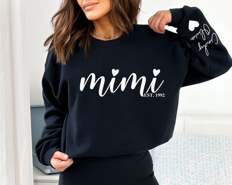 May include: Black sweatshirt with white text that reads "mimi est. 1992" with two small white hearts on either side of the word "mimi".