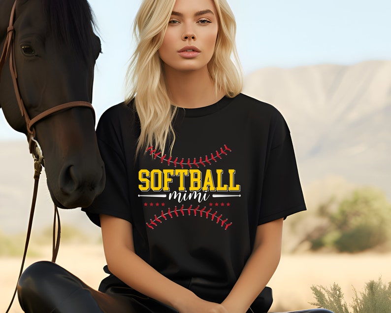 May include: Black t-shirt with a yellow and red graphic of a baseball with the text "SOFTBALL mimi" on it.