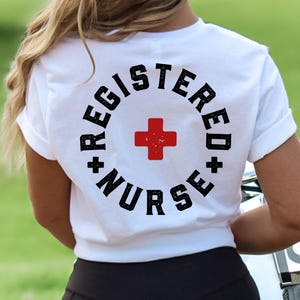 May include: White t-shirt with a black circle graphic that says "Registered Nurse" with a red plus sign in the center.