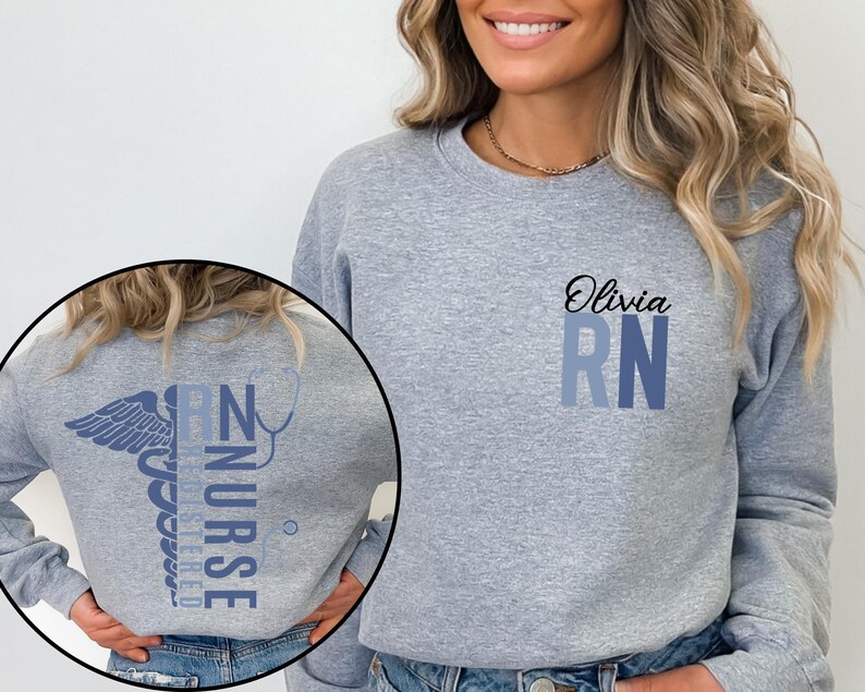 May include: A gray sweatshirt with a blue and white medical caduceus graphic on the back and the text "RN" with the name "Olivia" above it on the front.