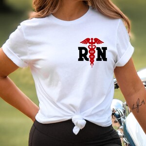 May include: White t-shirt with a red medical symbol and the letters "RN" in black.