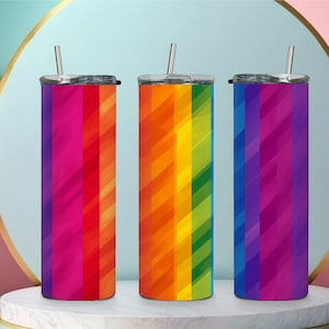 Puede incluir: Tres vasos de acero inoxidable con tapas y pajitas. Cada vaso presenta una variación de color diferente de un patrón de arcoíris.