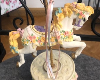 Caballo de carrusel decorado con caja de música y rosas gira en sentido antihorario….
