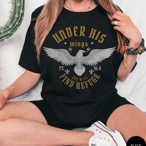 May include: Black t-shirt with a gold graphic of an eagle with the text "Under His Wings" and "Ps. 91:4 You Will Find Refuge".