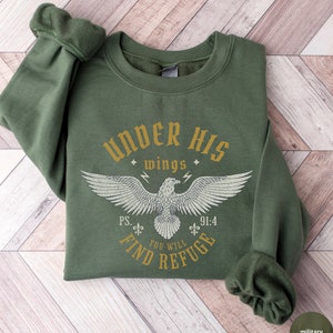 May include: A green sweatshirt with a white eagle graphic and the text "UNDER HIS wings PS. 91:4 YOU WILL FIND REFUGE".