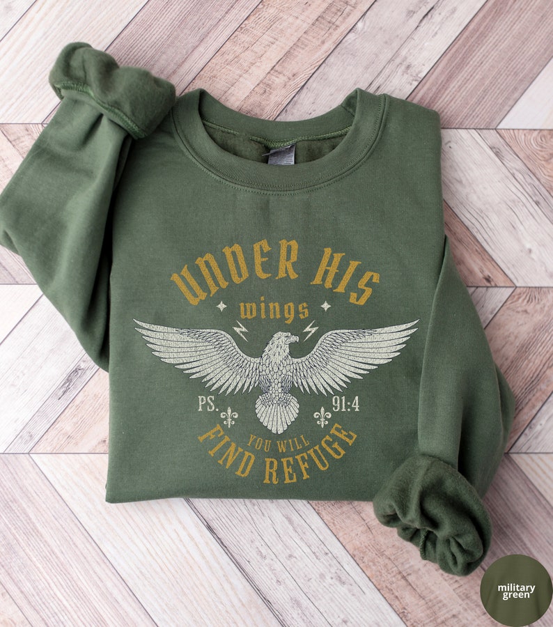 May include: A green sweatshirt with a white eagle graphic and the text "UNDER HIS wings PS. 91:4 YOU WILL FIND REFUGE".