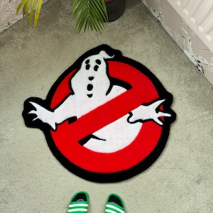 May include: A red and black doormat with a white ghost in the shape of the Ghostbusters 'no ghosts' logo.