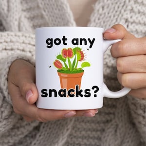 A double-sided funny Venus Fly Trap mug with &quot;Got Any Snacks?&quot; – perfect for plant lovers with a sense of humor!