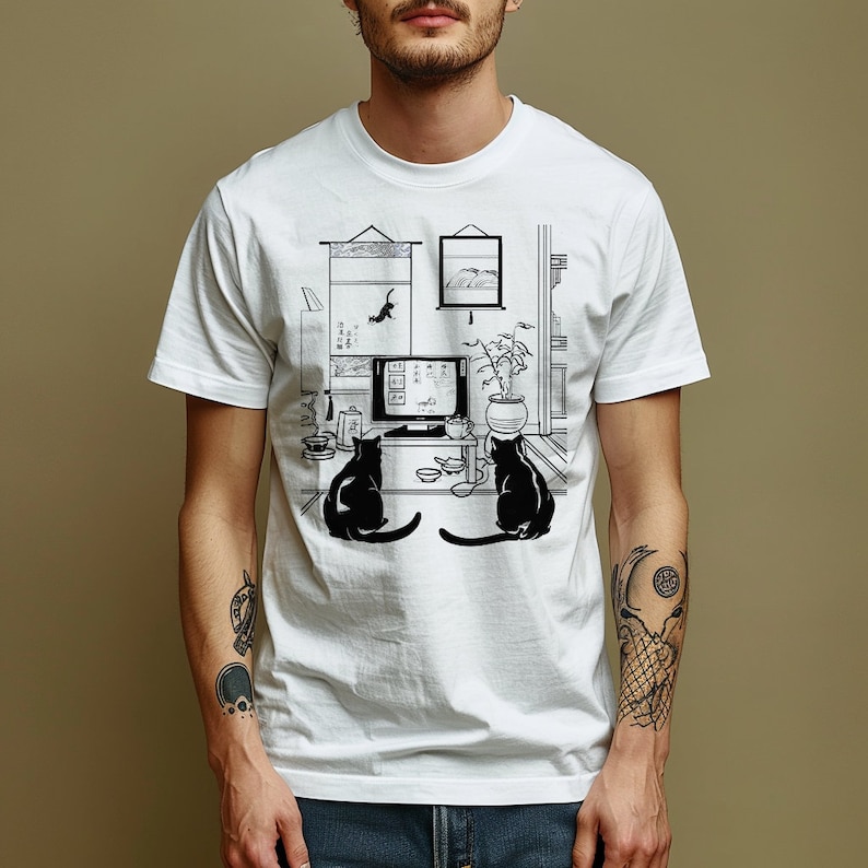 May include: White t-shirt with a black and white illustration of two cats watching television in a room with a potted plant and a scroll hanging on the wall.