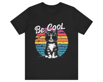 May include: Black t-shirt with a retro-style graphic of a cat wearing sunglasses and the text "Be Cool".