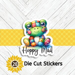 May include: A die-cut sticker featuring a colorful patchwork frog with large eyes and a smiling expression. The sticker includes the text Hoppy Mail in a black script font. Below the frog, the text 20 Die Cut Stickers is displayed.