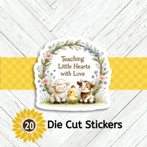 May include: Die-cut stickers featuring a charming illustration of a lamb, chick, and cow. The design includes the text "Teaching Little Hearts with Love" surrounded by a floral wreath. The stickers are set against a yellow and white background.