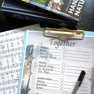 May include: A checklist with the word "Together" at the top. The checklist has five numbered sections, each with a list of activities to choose from. The activities include "Hurlburt", "Poetry", "Art Study", "Hymn Study", "Nature Study", "El Principito", "Pro Peep", "Indescribable", "Beethoven", "Hymn", "Folk Song", and more. A black pen is lying on top of the checklist.