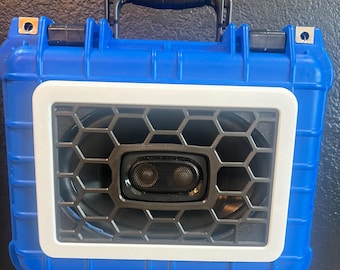 May include: A blue hard-shell case with a white frame around a speaker with a black honeycomb grille. The speaker has a black driver with two silver tweeters.