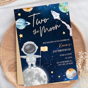 May include: An astronaut in a blue and white spacesuit stands on a grey moon holding a yellow flag. The background is a dark blue night sky with stars, planets, and a rocket ship. The text reads "Two the Moon" and "Kevin's 2nd Birthday! March 27th at 2 PM 123 Anywhere St. Any City, ST 12345".