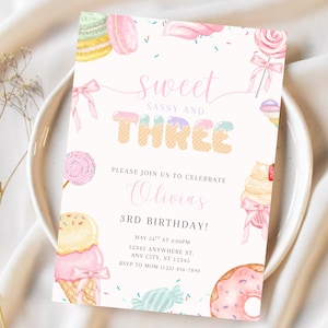 以下が含まれることがあります： 「Sweet, Sassy and Three」の文字が入ったパステルカラーの誕生日招待状。アイスクリームコーン、ロリポップ、ドーナツなど、お菓子を水彩画で描いています。オリビアの3歳の誕生日のお祝いの招待状です。