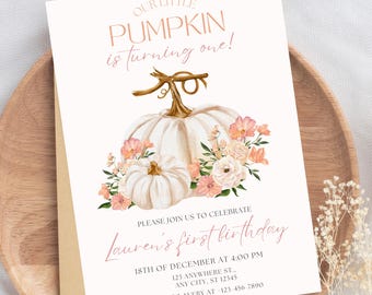 May include: A birthday invitation with a pumpkin theme. The text "Our Little Pumpkin is turning one!" is at the top. The invitation includes the text "Lauren's first birthday" and event details. The design features white pumpkins and floral accents.