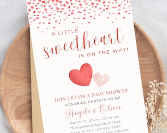 May include: A baby shower invitation with a pink and red watercolor heart design. The invitation reads "A Little Sweetheart is on the Way!" and includes the names Angela and Oliver, the date March 13, 2024, and the time 12:00 pm.