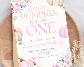 May include: A light pink and white invitation with the text "Our Little Pumpkin is Turning One." The invitation includes watercolor pumpkins and floral accents. The text "Lauren's first birthday" is also included.