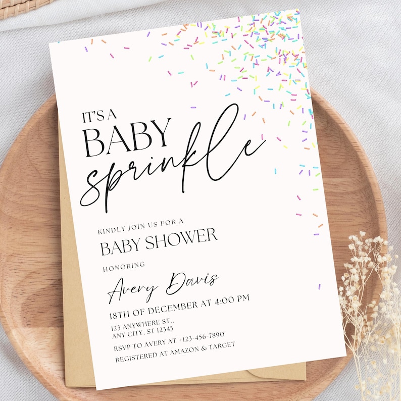 May include: A white baby shower invitation with a colorful sprinkle design. The text reads "It's a Baby Sprinkle" and includes the name Avery Davis, the date and time of the shower, and the address. It also includes RSVP information and where the guest of honor is registered.