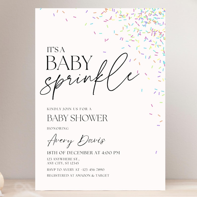 May include: A white baby shower invitation with colorful sprinkles in the background. The text reads "It's a Baby Sprinkle" and includes the name Avery Davis, the date and time of the shower, and the address. It also includes RSVP information and where the couple is registered.