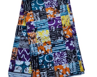 May include: A colorful fabric with a patchwork design. The pattern features squares of teal, orange, purple, yellow, and white, with floral and geometric motifs. The fabric has a tag that reads "QUALITE REAL Gingavy WAX".