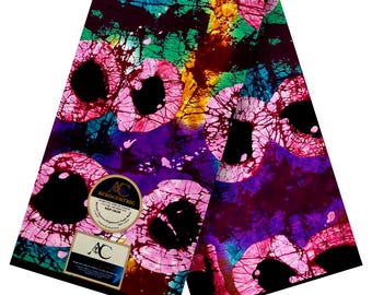 May include: A vibrant fabric with a batik-style design. The pattern features large, circular shapes in shades of pink, black, purple, green, and yellow. The fabric has a label that reads "Afrocentric" and "Veritable Print".
