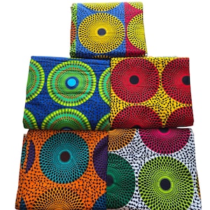 May include: Four pieces of colourful fabric with a circular pattern. The fabric is a mix of blue, green, yellow, red, orange, white, and black.
