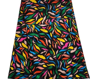May include: A black fabric with a colorful abstract pattern of green, blue, yellow, pink, and orange. The fabric has a white border and the text "WX BLOCK PRINTS HITarget 32831C" is printed on the bottom edge.