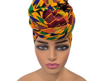 Puede incluir: Un turbante para la cabeza con estampado amarillo, verde, rojo y azul. El turbante está anudado en la parte superior de la cabeza.