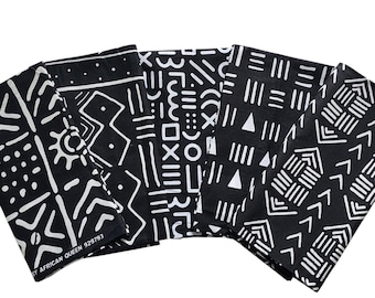 Può includere: Cinque quadrati di tessuto neri con motivi geometrici bianchi. Ogni quadrato presenta un design diverso, tra cui linee, triangoli e forme. Il testo "BY AFRICAN QUEEN 929793" è stampato su uno dei quadrati.