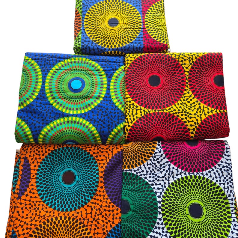 May include: Five fabric swatches featuring a circular pattern. The fabrics are in a variety of colours, including blue, green, red, orange, and yellow. The circles have a black outline and a white centre.