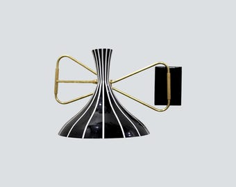 May include: A mid-century modern wall sconce with a black and white striped shade. The fixture has brass-colored arms and a black rectangular mounting plate. The design is retro and stylish.