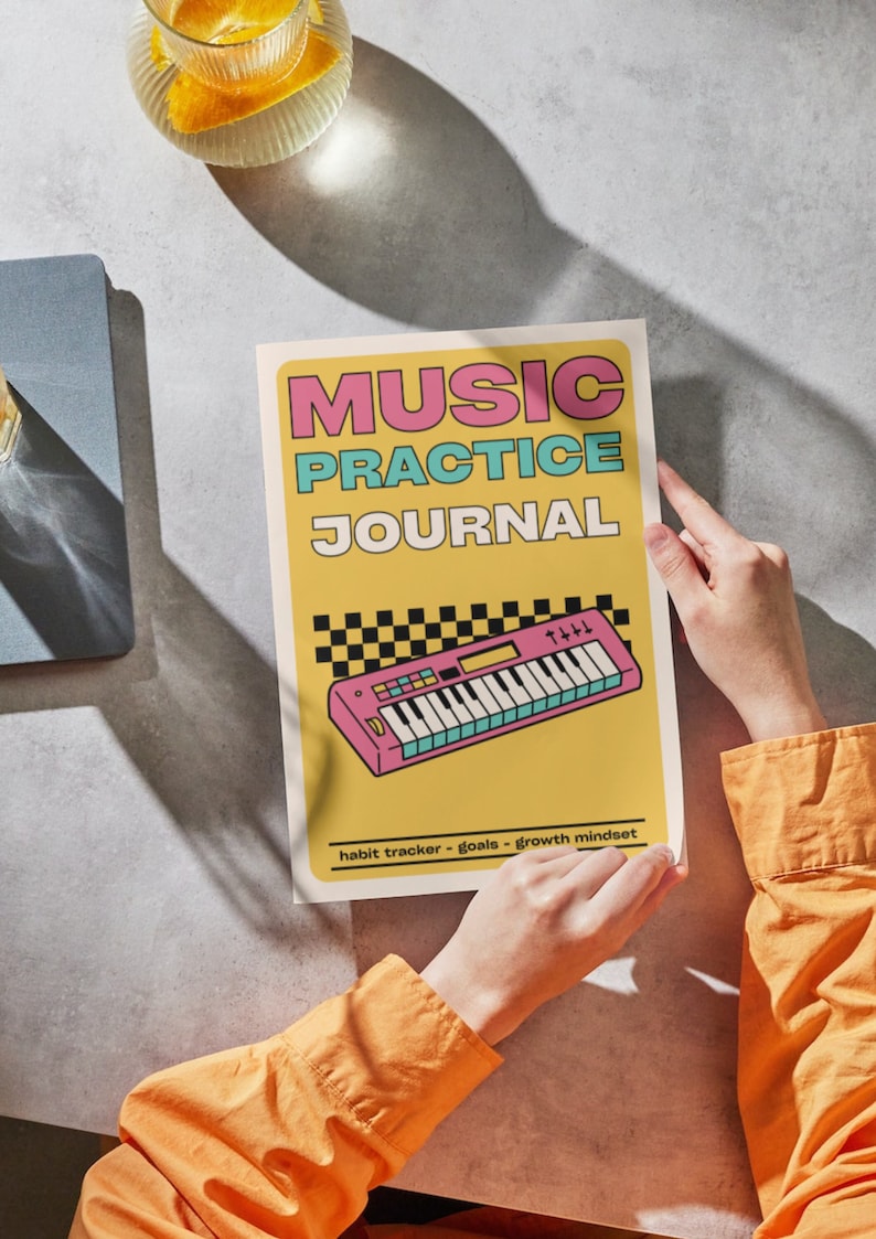 May include: A music practice journal with a yellow cover featuring the text MUSIC PRACTICE JOURNAL in pink and blue, a graphic of a pink synthesiser, a black and white checkered pattern, and the text habit tracker - goals - growth mindset.