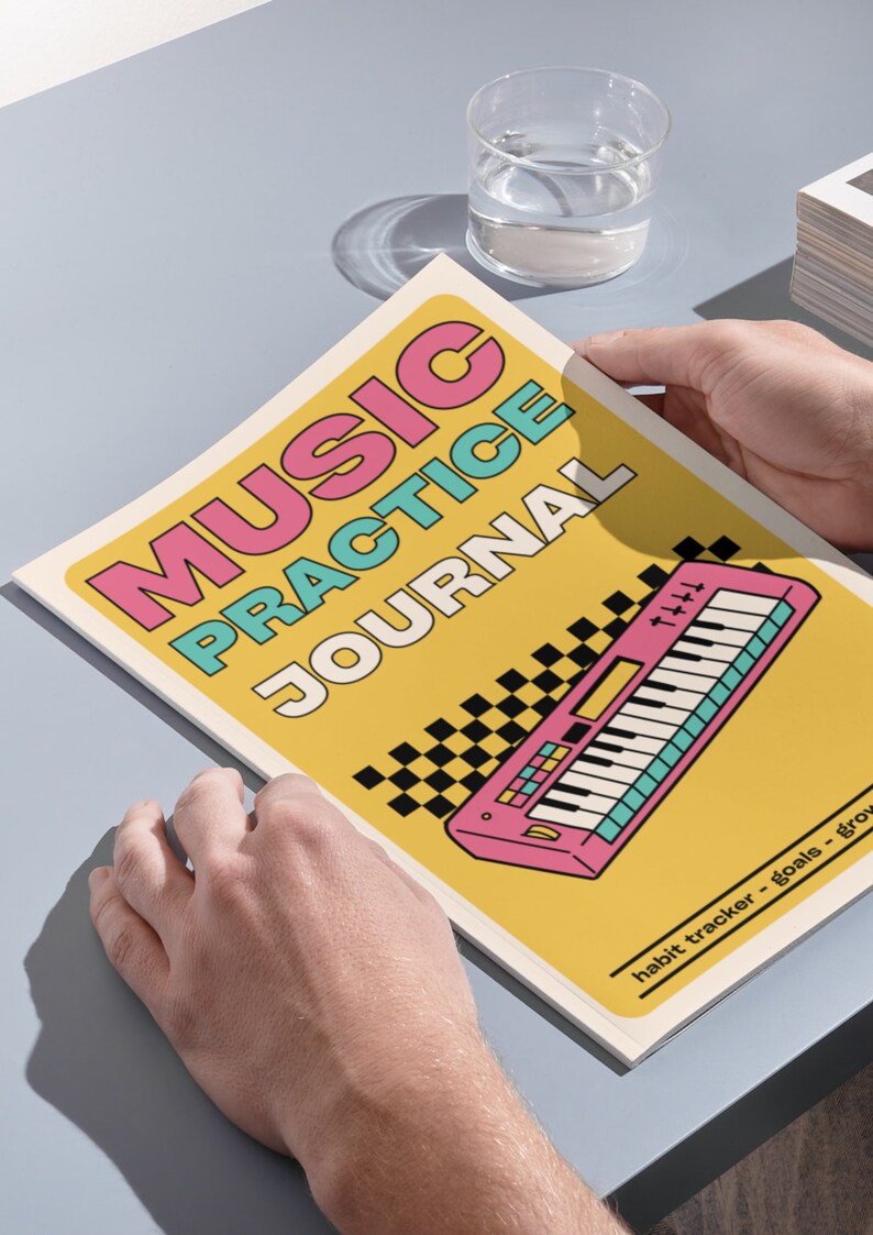 May include: A music practice journal with a yellow cover featuring the text MUSIC PRACTICE JOURNAL in pink and teal. The cover includes a graphic of a pink keyboard and a black and white checkered pattern, with the text habit tracker - goals - grow.