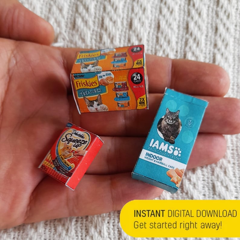 Pode incluir: Tr&ecirc;s caixas de comida para gatos. Uma caixa azul com um gato nela diz "IAMS: PROACTIVE HEALTH INDOOR WEIGHT & HAIRBALL CARE". Uma caixa vermelha diz "Delicately Squeeze Up". Uma caixa azul e laranja diz "Friskies TREASURES 24 CANS 2X".