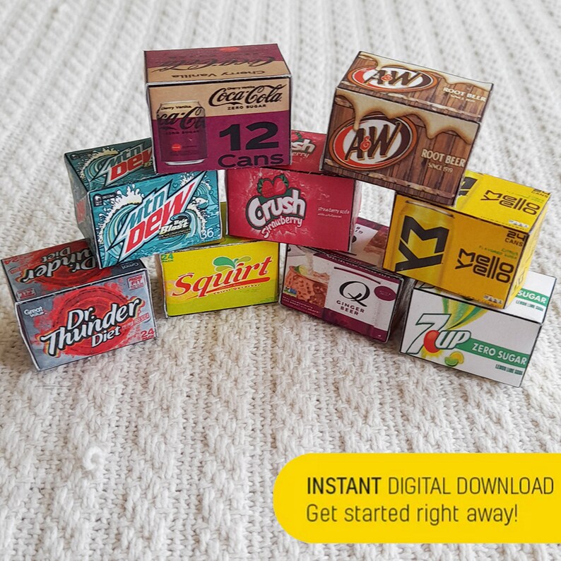 May include: A collection of miniature cardboard boxes featuring various popular soda brands, including Coca-Cola, Crush, Mello Yello, 7 Up, Dr. Thunder, Squirt, and A&W Root Beer. The boxes are stacked and arranged on a white textured surface.