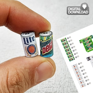 Może przedstawiać: Miniaturowe papierowe puszki piwa Lite i napoju gazowanego Mountain Dew. Puszka Lite jest biała ze złotym i niebieskim emblematem. Puszka Mountain Dew jest zielona, niebieska i czerwona. Arkusz do pobrania cyfrowego znajduje się w tle.