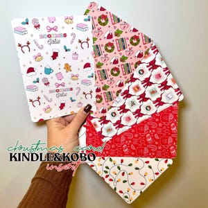 Può includere: Una collezione di inserti a tema natalizio per dispositivi Kindle e Kobo. Gli inserti presentano motivi festivi con bastoncini di zucchero, libri e icone delle vacanze. Il testo "Bookmas Girlie" è visibile su un inserto. La combinazione di colori include rosso, rosa e bianco.