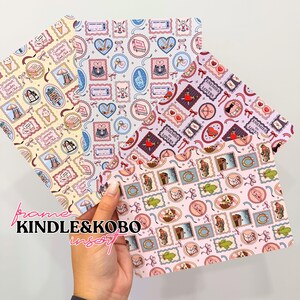 Peut inclure: Trois inserts rectangulaires pour liseuse électronique avec des motifs répétitifs illustrés. Une feuille a un fond jaune avec des thèmes estivaux, une est bleu clair avec du hockey et une est rose avec des motifs de style western.