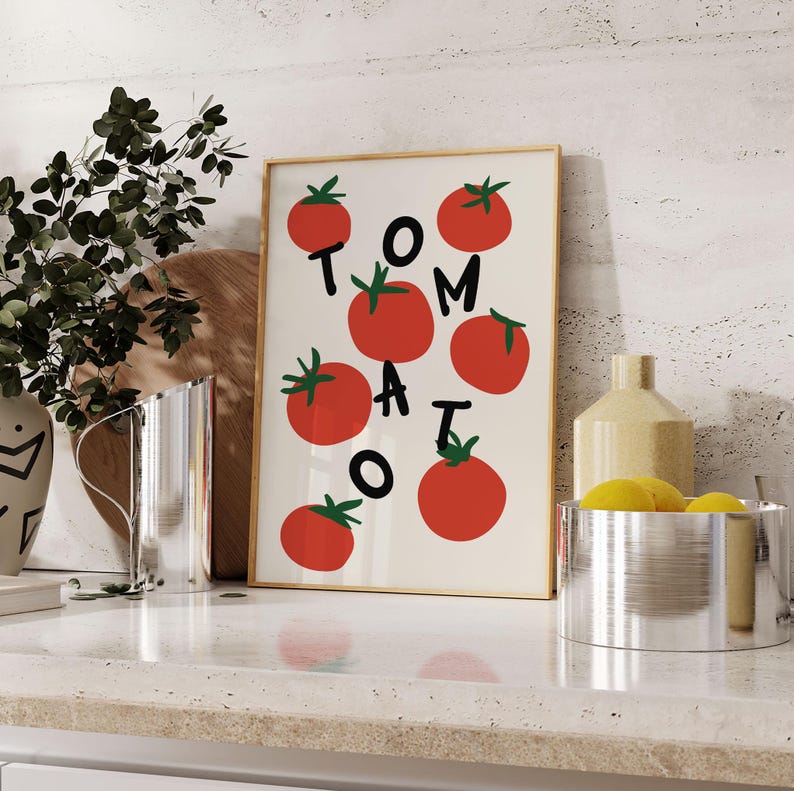 May include: A white framed print with the word "TOMATO" spelled out in red letters with red tomato illustrations surrounding the letters.