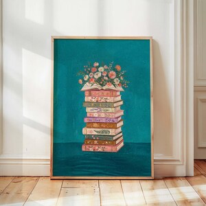 May include: A framed art print featuring a stack of vintage books with floral designs. The top book is open, overflowing with a bouquet of pink, white, and orange flowers. The background is a teal color.
