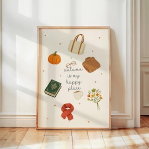 May include: A framed print featuring autumn-themed illustrations. It includes a pumpkin, a tote bag, a sweater, a book, a scarf, a cup of coffee, a bouquet of flowers, and the text "autumn is my happy place."