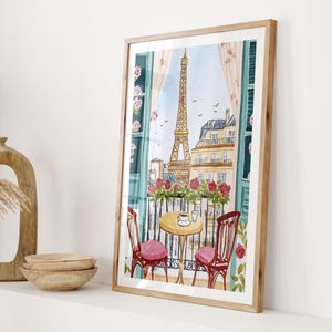 May include: Watercolor print of a Parisian balcony scene with the Eiffel Tower in the background. The artwork features a small table with two chairs, a cup of coffee, and a view of the city. The frame is a light wood color.